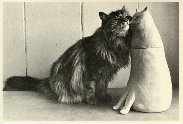 Cat nuzzles cat sculpture